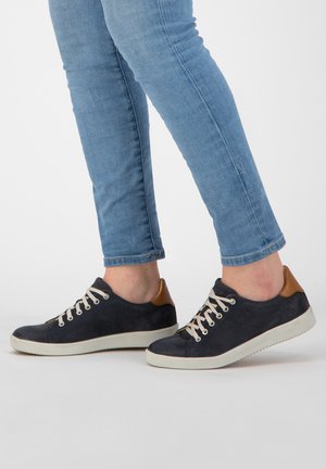 Dunkelblaue Wildlederschuhe mit hellen Schnürsenkeln und braunen Lederakzenten an der Ferse, die ein niedriges Profil und Gummisohlen aufweisen.