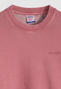 Ροζ φούτερ με ριμπ λαιμόκοψη, διαθέτει απαλό, υφασμάτινο εσωτερικό και κεντητό λογότυπο Levi's στο στήθος.