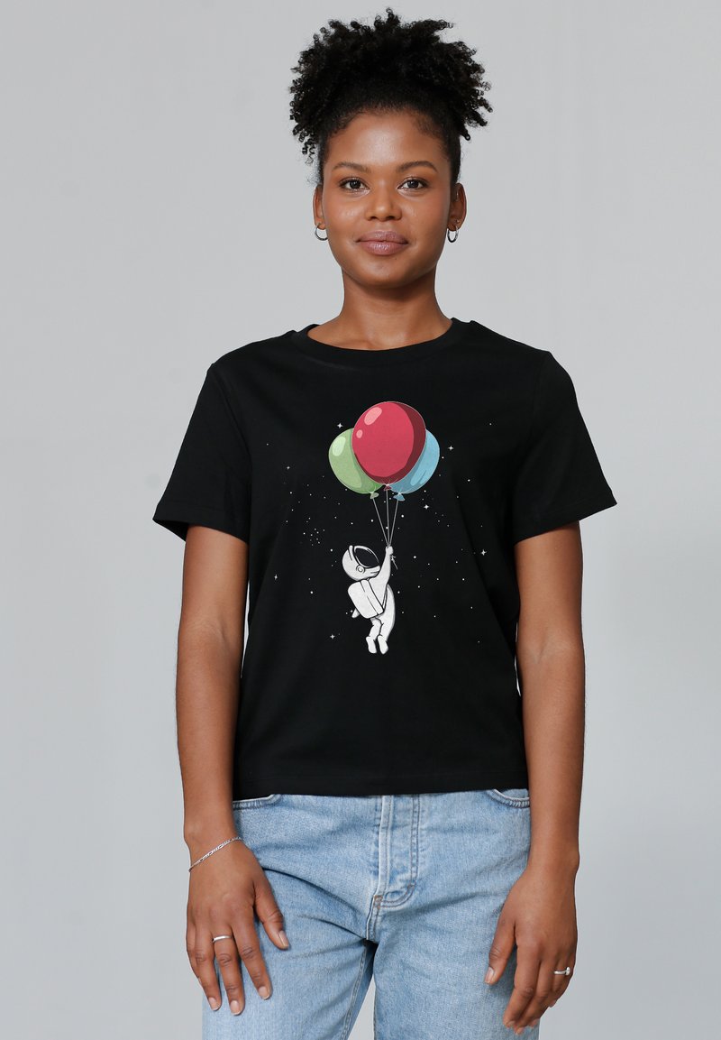 Schwarzes Baumwoll-T-Shirt mit einem weißen Astronauten-Graphic, der drei bunte Ballons (rot, grün, blau) vor einem sternenbesetzten Hintergrund hält.