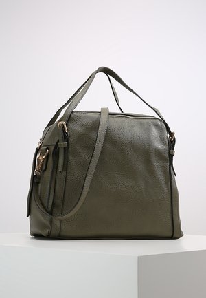 Borsa a tracolla in pelle verde oliva con texture, dotata di due manici, una tracolla removibile e una chiusura superiore con cerniera, su una superficie bianca.