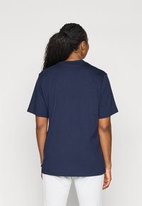 Mörkblå bomulls t-shirt med korta ärmar och rundad halsringning, med en rak baksida utan synliga logotyper eller mönster.