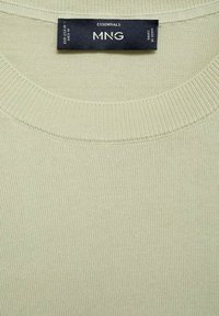 Pulover verde deschis cu guler rotund. Textură cu nervuri, țesătură tricotată, având un etichetă cu inscripția "MNG Essentials". Design simplu, fără modele.