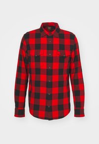 Rot-schwarzes karierter Flanellhemd mit Knopfverschluss, zwei Brusttaschen und einem Kragen. Der Stoff wirkt weich und zeigt ein klassisches Karomuster.