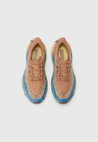 Sportschuhe mit einem strukturierten, braunen Obermaterial, blauen Akzenten und einer gelben Sohle. Sie verfügen über kontrastierende Muster und ein atmungsaktives Design.