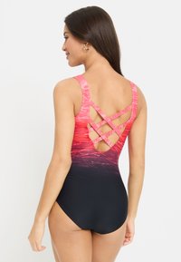 Maillot de bain une pièce avec un dégradé de rose à noir. Doté de bretelles épaisses et d'un dos entrecroisé. Fabriqué en tissu lisse et extensible.