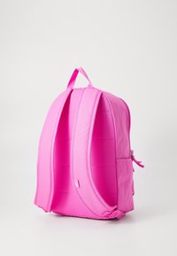 Roze rugzak met gewatteerde schouderbanden, ronde vorm en een ritsvak aan de zijkant. Gemaakt van duurzaam materiaal met een gestructureerd oppervlak.