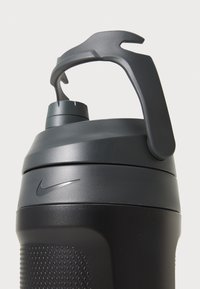 Zwarte plastic waterfles met een gestructureerde grip, schroefdop en een handvat. Voorzien van een klein Nike-logo op de zijkant.