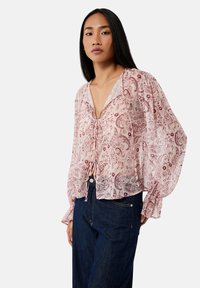 Doorzichtig blouse met een paisleypatroon in zachte roze en rode tinten. Beschikt over een V-hals, een strikdetail aan de voorkant en volumineuze mouwen.