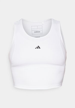 Crop top de sport blanc en tissu léger et respirant. Présente des panneaux latéraux en mesh et un logo noir brodé sur la poitrine.