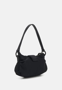 Svart tyghandväska med en slät yta, dragkedjestängning och ett kort handtag. Har subtila rynkor på sidorna och en präglad logotyp på framsidan.