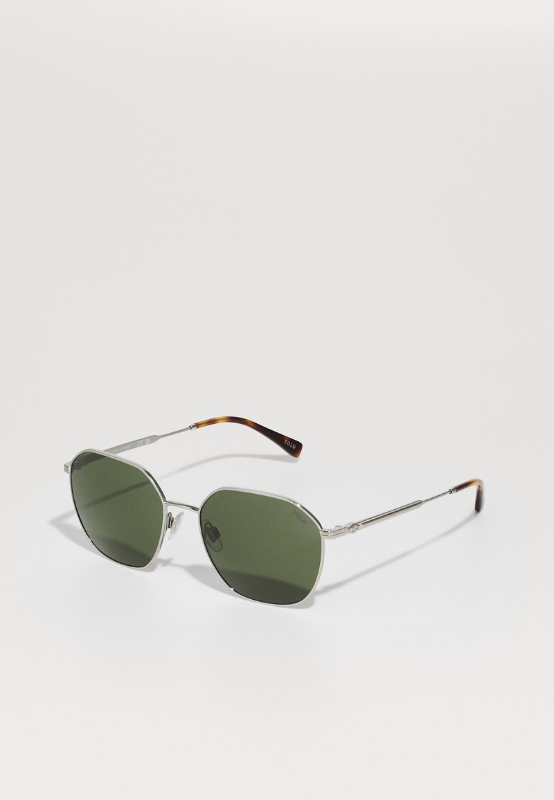 Óculos de sol com armação metálica prateada e lentes verdes, forma octogonal, com detalhes em tartaruga nas hastes. Acabamento polido.