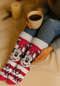 Calzini a maglia con un polsino bianco morbido, caratterizzati da un design di personaggio dei cartoni animati in strisce rosse, nere e bianche. Texture in tessuto morbido.