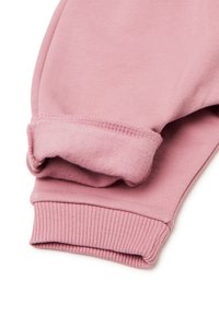 Růžové bavlněné tepláky se žebrovanými manžetami a hladkým povrchem. Materiál je elastický a jemný, s jednoduchým, nezdobeným designem.