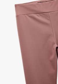 Leggings in einer gedämpften Rosafarbe, aus weichem, dehnbarem Stoff gefertigt. Sie verfügen über einen glatten Bund und ein elegantes, schmal zulaufendes Bein-Design.