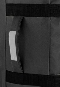 Sección de mochila de tela gris con superficie texturizada, asa gris y correas negras, que ofrece un diseño funcional sin adornos.