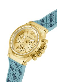 Orologio cronografo dorato con lunetta in cristallo, cinturino in gomma blu con motivo e quadrante rotondo con quadranti in tonalità dorata e tre sottodial.