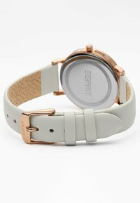 Weißes Lederarmbanduhr mit einem Gehäuse aus roségoldfarbenem Edelstahl, runder Zifferblatt und dekorativer Schnalle. Verfügt über ein minimalistisches Design.