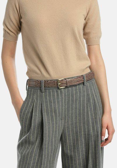 Ceinture marron à motif crocodile avec une boucle dorée portée sur un pantalon rayé gris et un haut en maille beige, mettant en valeur un design texturé et ajusté.