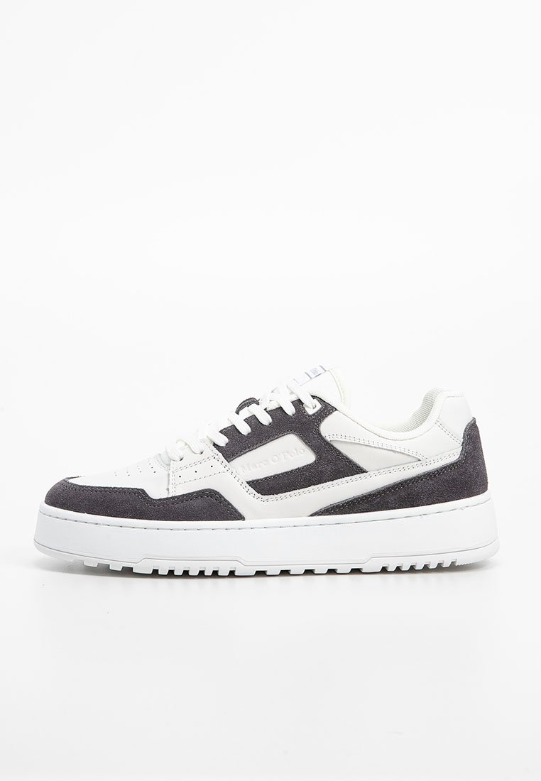 Weiße Low-Top-Sneaker mit schwarzen Wildlederüberzügen, weißen Schnürsenkeln und dicker weißer Gummisohle, seitlich auf einem weißen Hintergrund dargestellt.