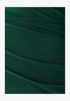 Dunkelgrüner, strukturierter Stoff mit sanften, fließenden Falten. Die Oberfläche weist ein dezentes Netzmuster auf, das Tiefe und visuelles Interesse erhöht.