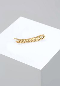 Clip para el cabello en forma de cadena dorada con un diseño curvado y alargado. Presenta un patrón texturizado que se asemeja a eslabones entrelazados. Acabado metálico suave.