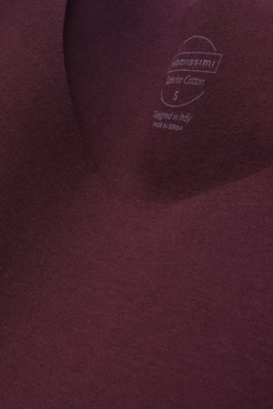 Bordeauxrotes Baumwoll-T-Shirt mit V-Ausschnitt, glatter Textur und einem aufgedruckten Etikett, das Größe und Herkunft angibt.