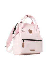 Sac à dos en tissu rose avec des bretelles réglables, des poignées supérieures, une poche zippée à l'avant et un patch rond au logo, présentant des coutures robustes et des accents minimalistes.