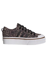 Baskets basses imprimées léopard avec lacets noirs et trois rayures noires. Elles présentent une semelle en caoutchouc blanche et une capot de protection texturé.