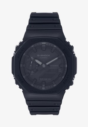 Sort G-Shock ur med mat finish, digital og analog skærm, tekstureret bezel og gummiarmbånd. Vandtæt til 20 bar.