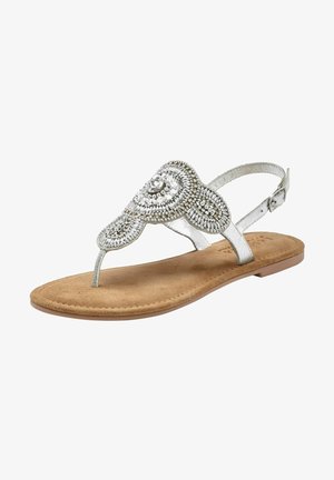 Zilveren platte sandaal met een decoratief beaded ontwerp, voorzien van een teenband en enkelband, rustend op een tan suède zool.