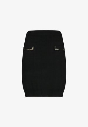 Minifalda negra con un diseño estructurado. Presenta detalles cuadrados con tachuelas en los bolsillos. Textura lisa y forma ajustada. Cintura elástica.