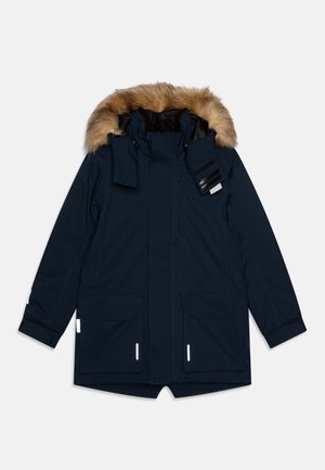 Parka blu navy con cappuccio foderato in pelliccia, chiusura frontale con cerniera, molteplici tasche e dettagli riflettenti. Realizzato in materiale impermeabile.