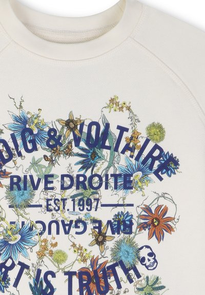 Tela blanca con ilustraciones botánicas coloridas y texto en azul marino que dice "Zadig & Voltaire", "Rive Droite", "Est. 1997" y un pequeño icono de calavera.