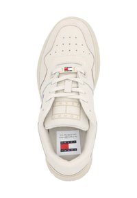 Baskets beiges avec lacets, bout perforé et logo Tommy Jeans sur la languette et la semelle intérieure, vues de dessus.