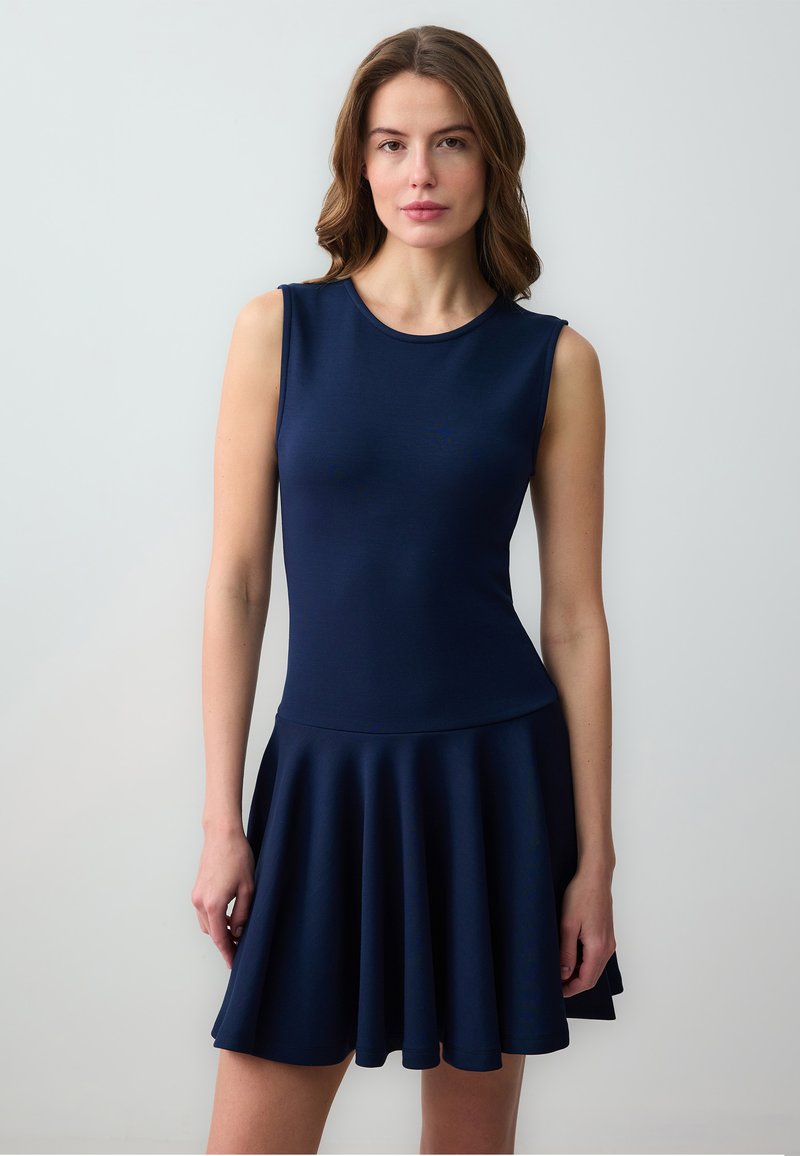 Robe sans manches navy avec un buste ajusté, une jupe évasée, une texture lisse et un col rond. Design simple et couleur unie sur toute la surface.