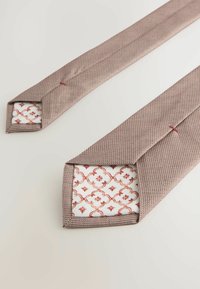Woven tie w bordowym i beżowym kolorze z geometrycznym wzorem; ostre końce odsłaniają kontrastującą wewnętrzną tkaninę w białym kolorze z czerwonymi motywami kwiatowymi.
