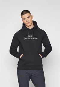 Sudadera negra con bolsillo canguro, capucha con cordón y texto "Rendimiento Ideal". Presenta mangas raglán y puños acanalados.