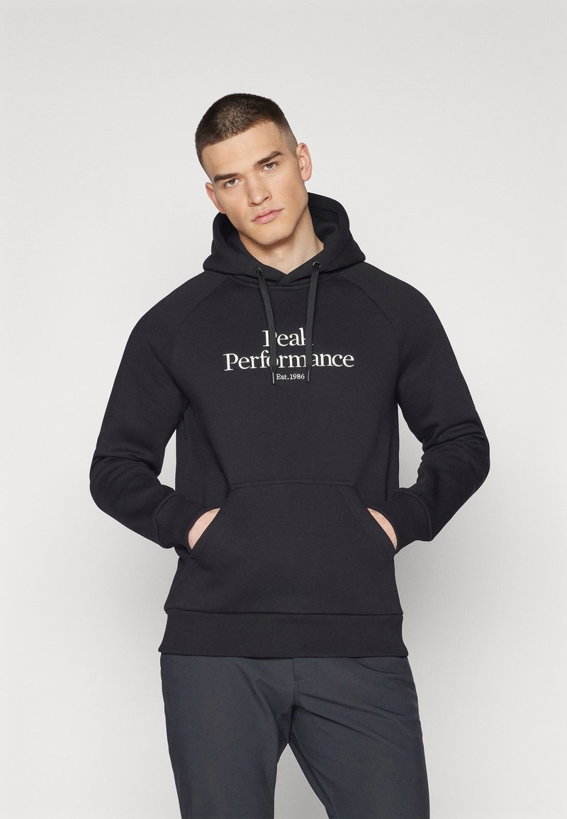 Sudadera negra con bolsillo canguro, capucha con cordón y texto "Rendimiento Ideal". Presenta mangas raglán y puños acanalados.