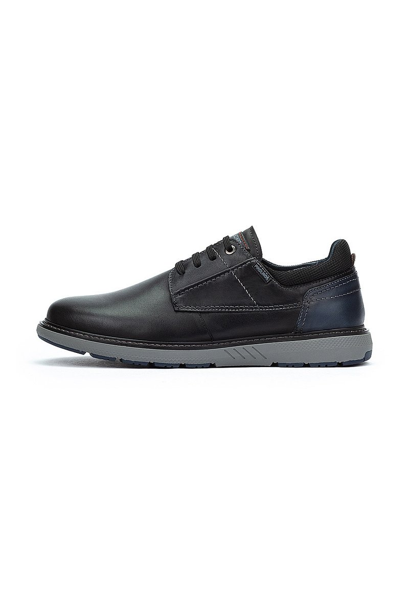 Scarpe in pelle nera con finitura liscia, dotate di suole in gomma grigia, sei occhielli e un sottile accento blu sul tallone.