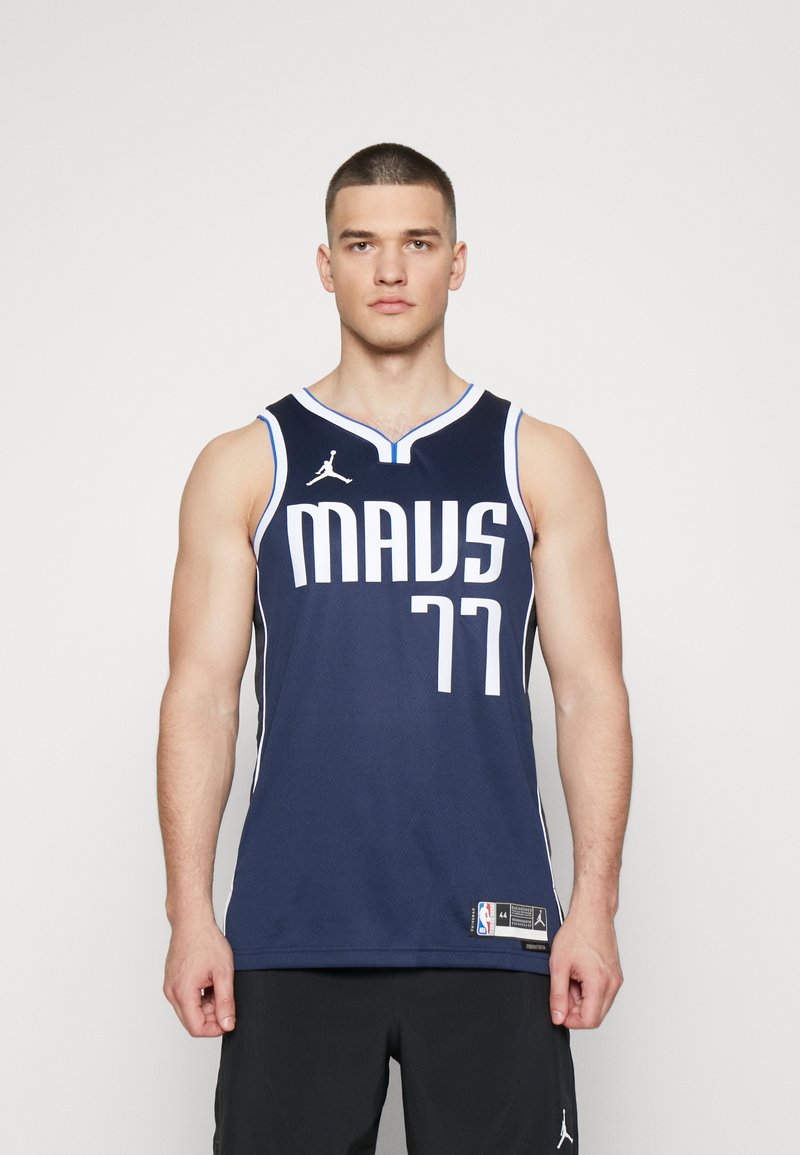 Marineblå basketballtrøje med hvide "MAVS"- og "77"-grafikker. Har en rund hals, meshlignende tekstur og et Jordan-logo på brystet.