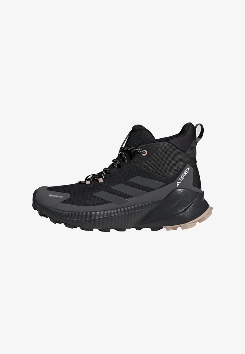 Scarpa da trekking Adidas Terrex nera alta con Gore-Tex, suola texturizzata e supporto imbottito alla caviglia, vista laterale su sfondo bianco.