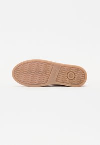Suola di scarpa in gomma beige con un motivo testurizzato e ondulato, completata da un accento circolare e marchio "Gabor", progettata per garantire aderenza e durata.