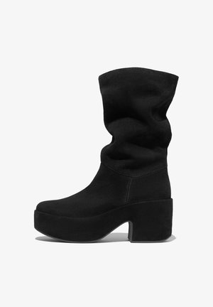 Black suede ankle boot with a slouchy upper, thick platform sole, and a chunky block heel. Features visible stitching along the seams.