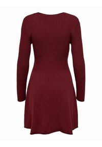 Abito in maglia a coste bordeaux con maniche lunghe, busto aderente e gonna svasata. Realizzato in un morbido tessuto a maglia testurizzato.