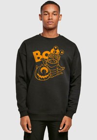 Fekete pulóver, narancssárga grafikával, amelyen egy rajzfilmfigura és egy tök látható a "Boo" felirattal. Klasszikus kerek nyakkivágás és hosszú ujjú.