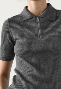 Szary, prążkowany top polo z krótkim rękawem, z półzamkiem przy kołnierzyku i teksturowaną tkaniną, prezentujący dopasowany fason.