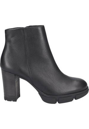 Schwarze Knöchelstiefel aus strukturiertem Leder, mit einem massiven, geriffelten Absatz und einer glatten, abgerundeten Spitze, ausgestattet mit einem seitlichen Reißverschluss.