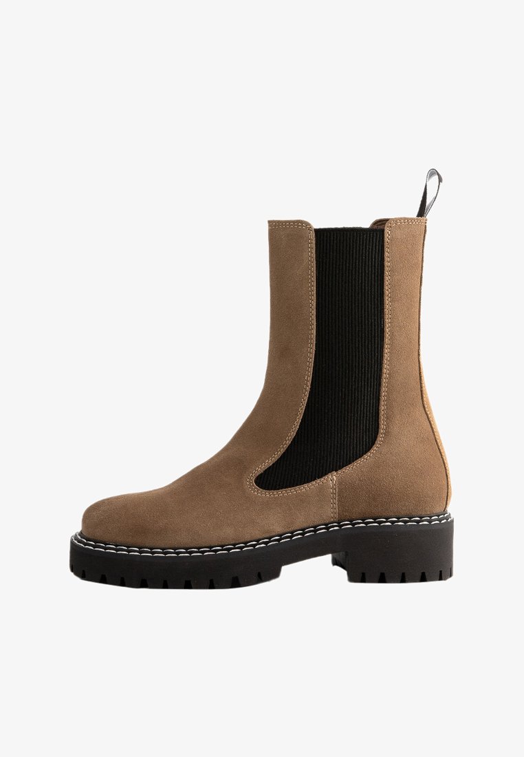 Brown suede ankle boot with black elastic panels and a chunky rubber sole. Notable white stitching along the sole edge. Smooth texture.