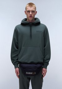 Felpa verde con tasca frontale e cappuccio regolabile, abbinata a una cintura fanny pack blu navy con un patch logo. Tessuto dal tocco morbido.