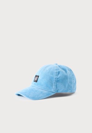 Helesinine sametiline pesapalli nokamüts kõverdatud visori ja väikese musta logoga ees tavalise tausta ees.